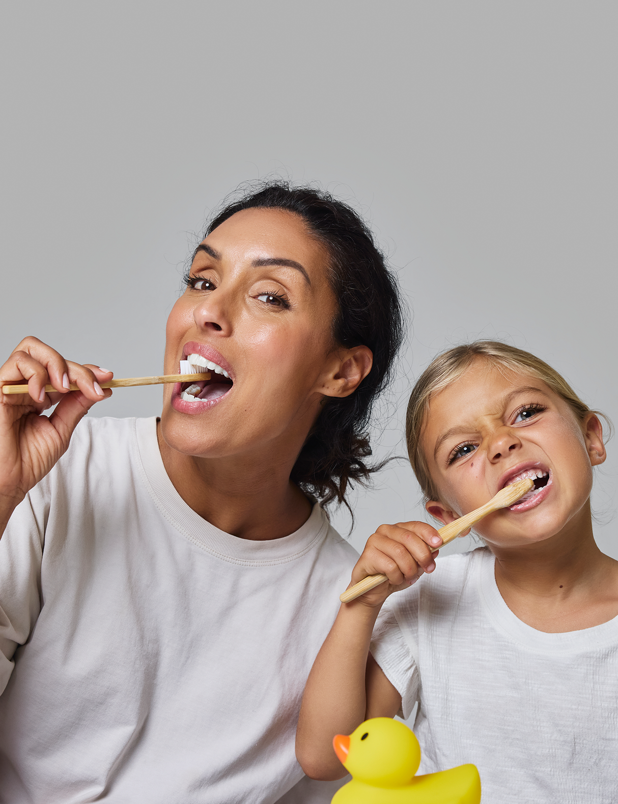 Two people brushing their teeth with Davids-Natural-Toothpaste-mild-mint