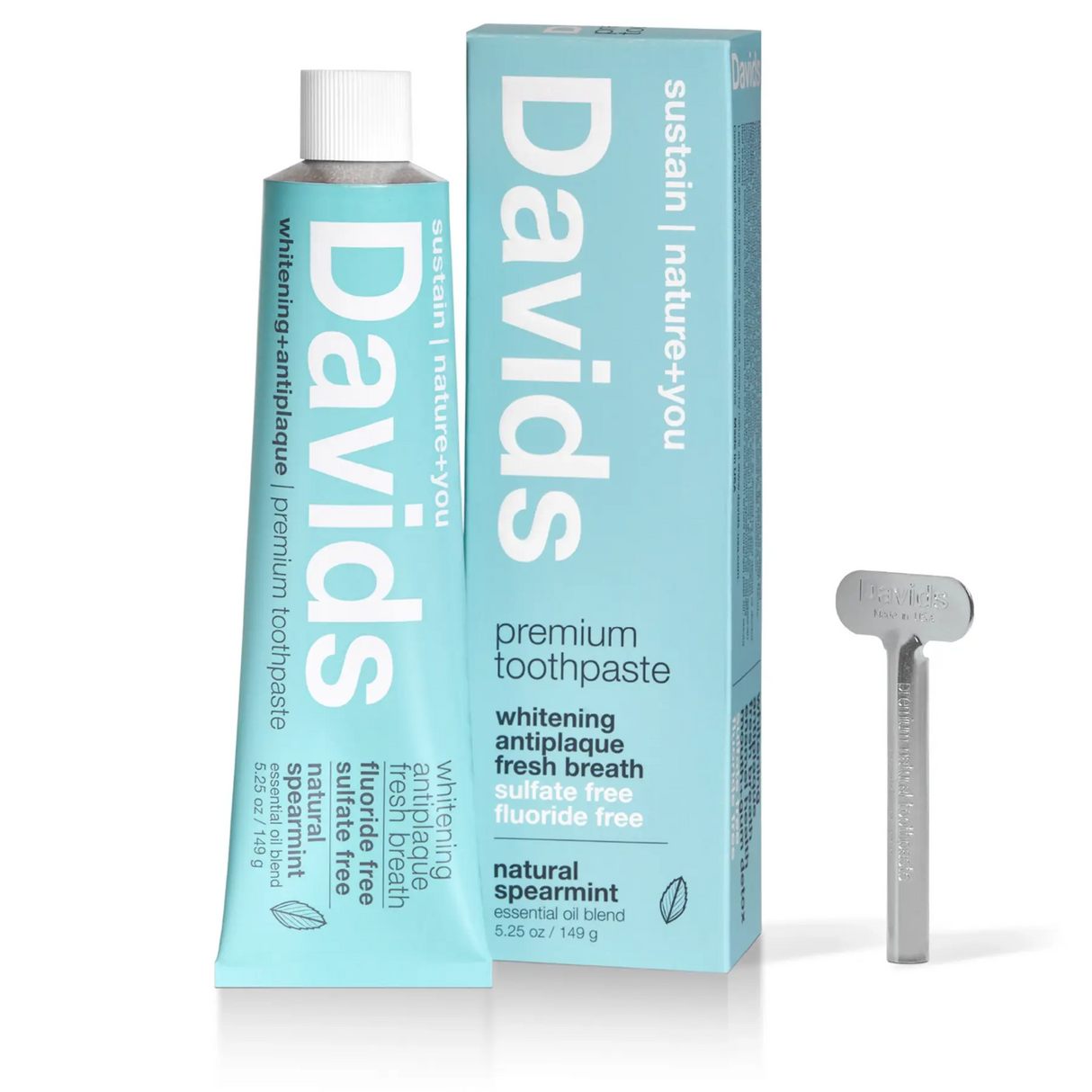 Davids toothpaste tube and packaging with a silver tongue scraper on a white background