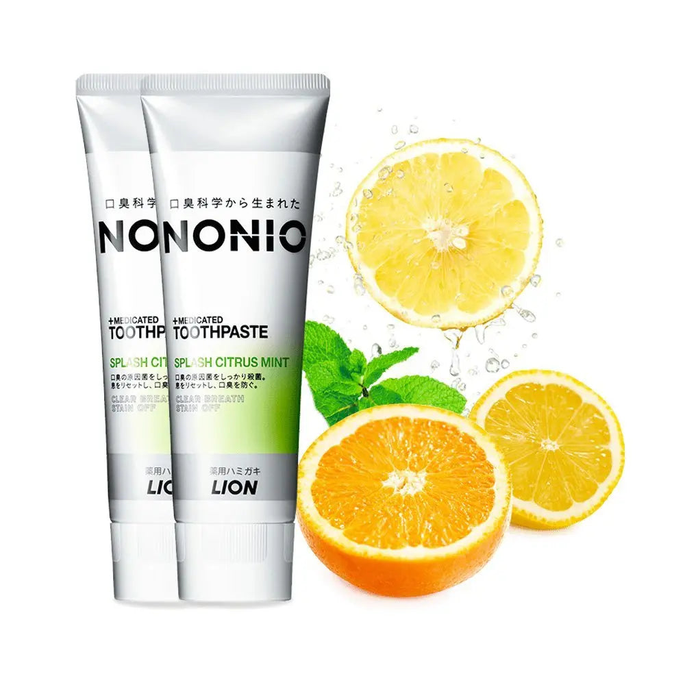 Two tubes of Nononio toothpaste with sliced oranges and mint leaves on a white background