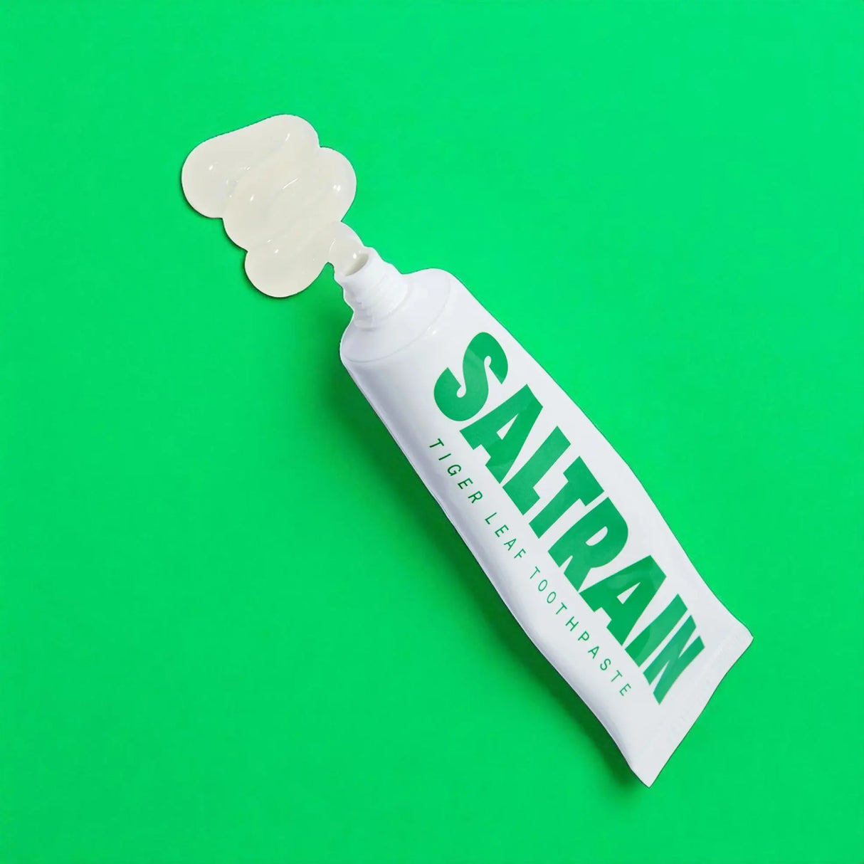 Saltrain toothpaste tube on a green background
