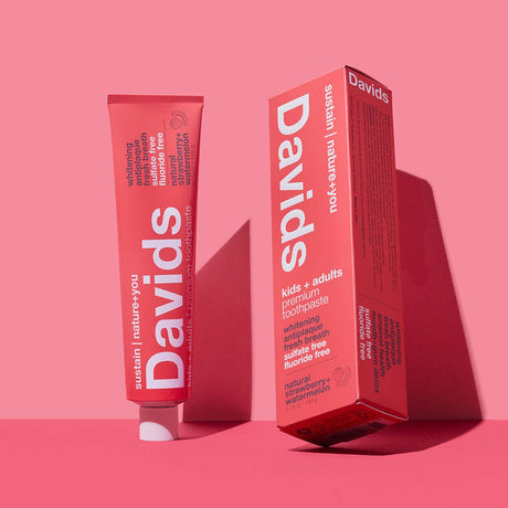 Packaging picture of Davids Natural Toothpaste in Strawberry and Watermelon flavour against a bright pink background