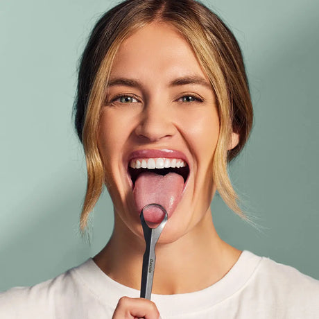 Woman using davids professional tongue scraper 