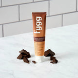 Fygg toothpaste tube with chocolate pieces on a white surface