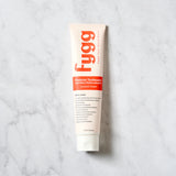 Fygg probiotic toothpaste tube on a marble background