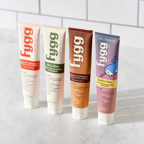 Four tubes of Fygg toothpaste on a white tiled background