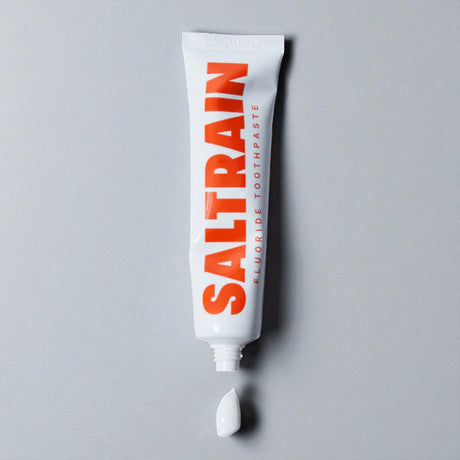 Saltrain fluoride toothpaste tube on a gray background