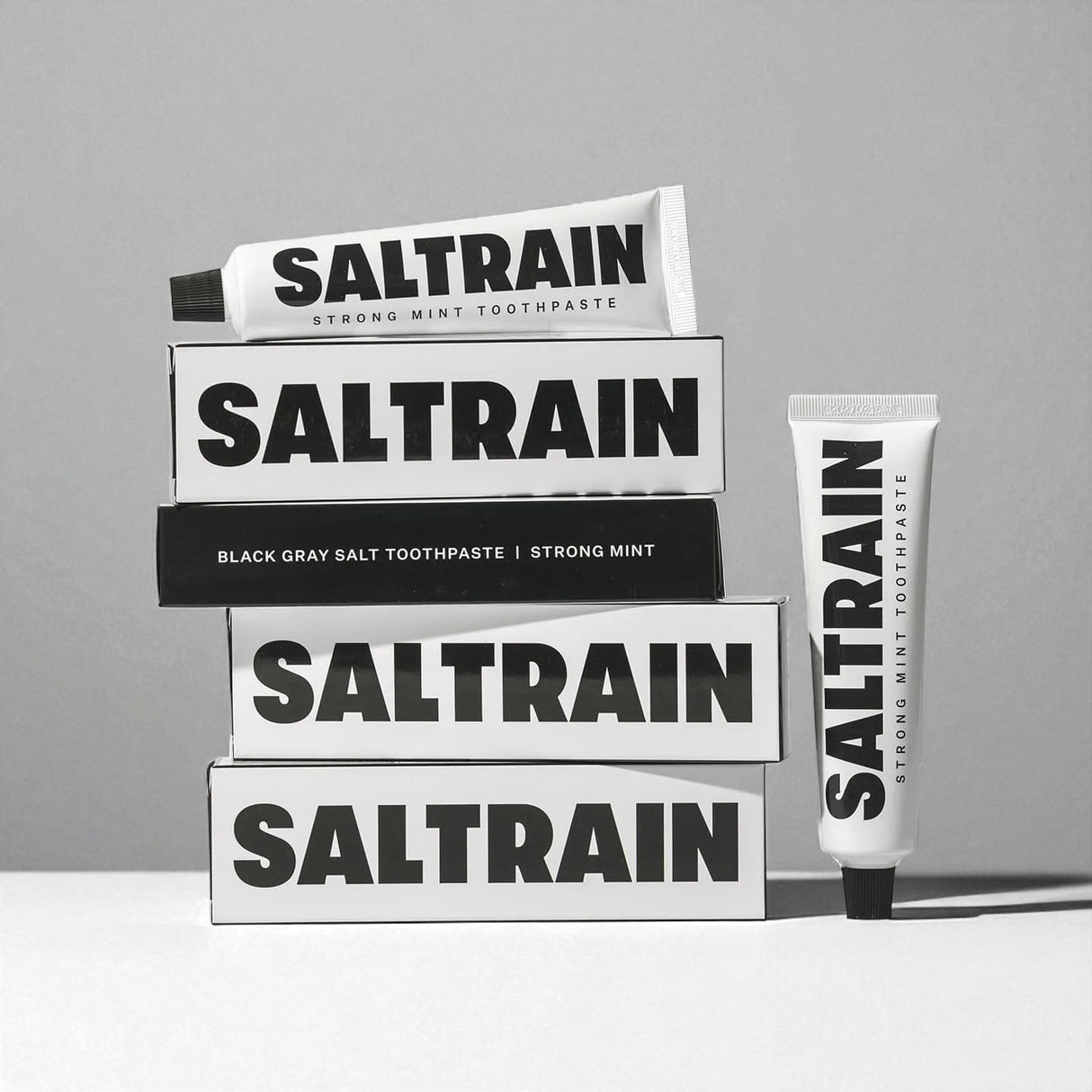 Saltrain toothpaste packaging on a gray background